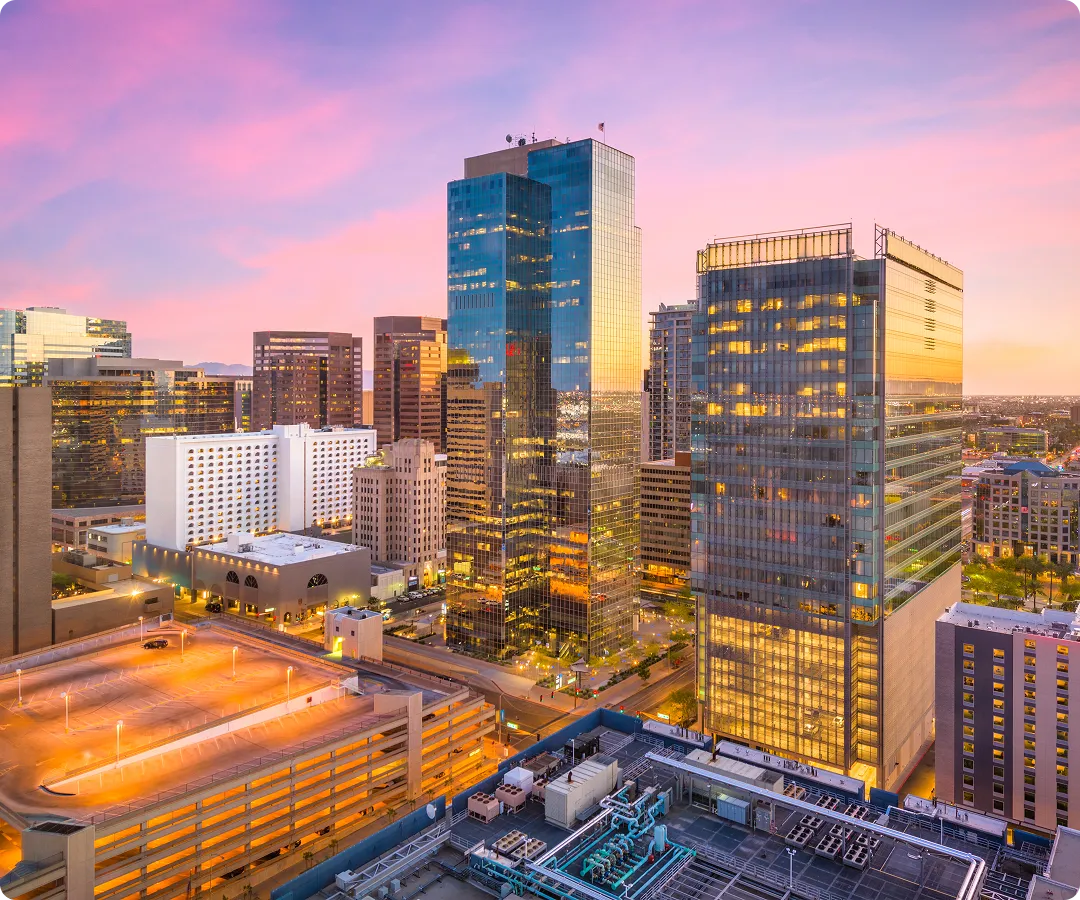 Tranquil park scene with green trees, a pond with ducks, and a wooden bridge.