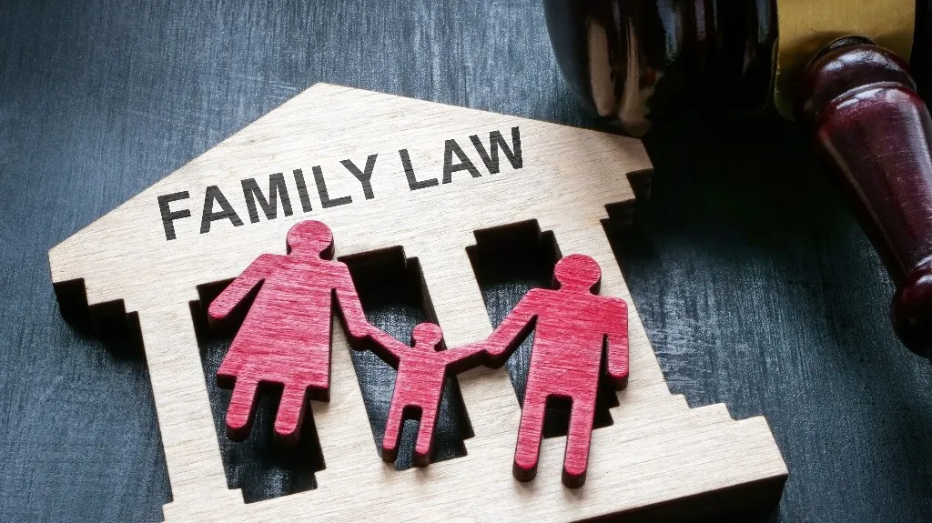 Wooden cutout of a family under a "Family Law" sign with a judge's gavel.