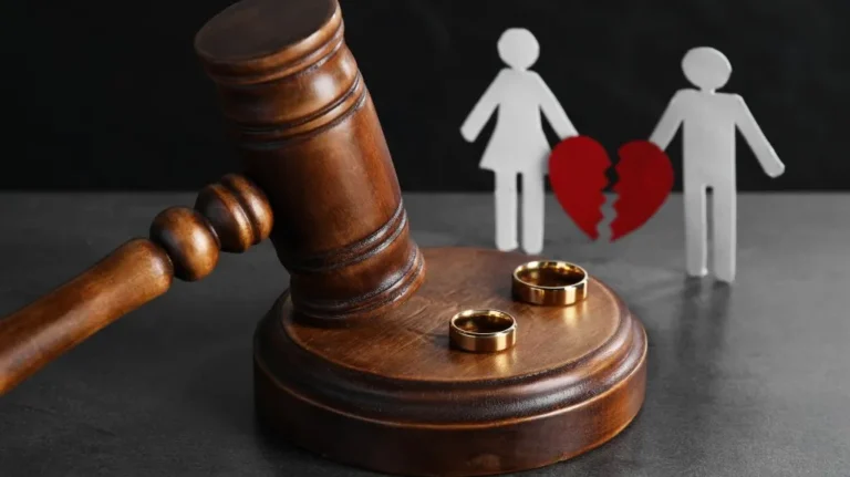Wooden judge's gavel with two wedding rings on base, separated male and female figures with broken red heart.